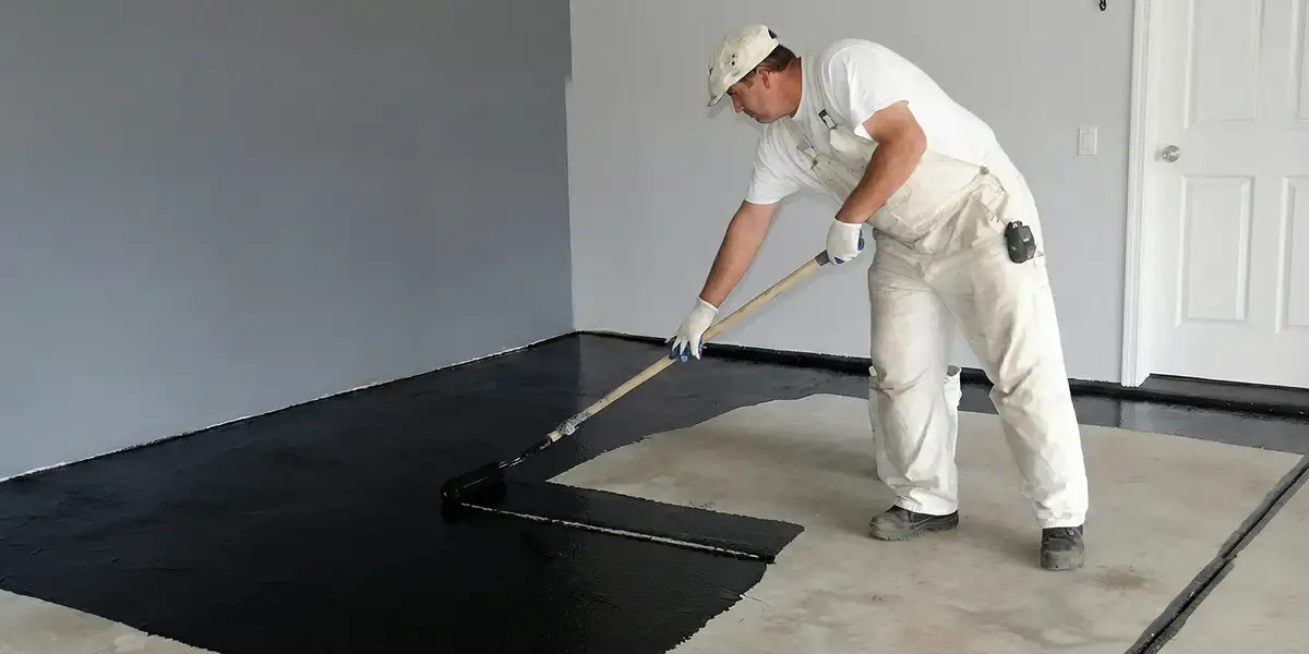 basement waterproofing professional applying waterproof coating to protect a basement floor in Colorado Springs, CO